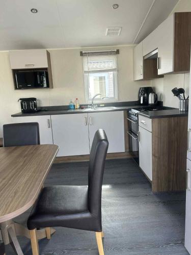 a kitchen with a table and a table and chairs at Newton Beach retreat in Porthcawl