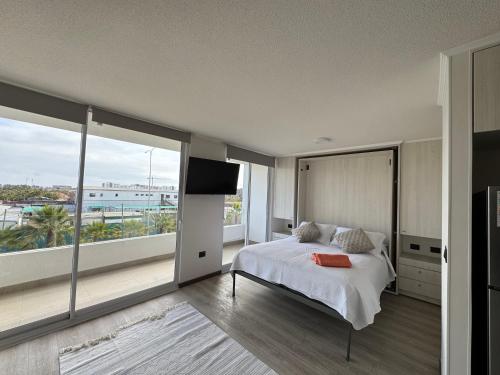 Un dormitorio con una cama grande y una ventana grande. en Home Studio La Serena, en La Serena
