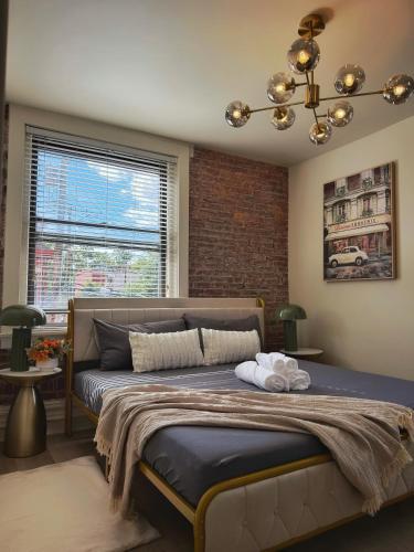 a bedroom with a large bed with a brick wall at 2 BEDS Free Parking Right Where You Want to Be in Pittsburgh