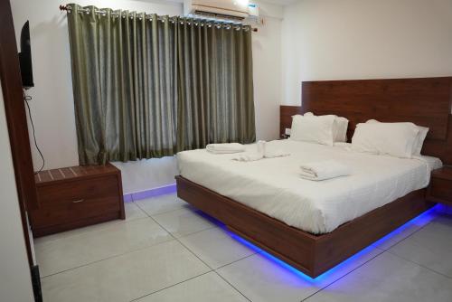 a bedroom with a bed with two towels on it at Pearl Residency Kalady in Kāladi