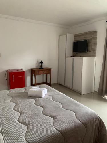 a bedroom with a large bed with two towels on it at Pousada Vô Nilo in Penha