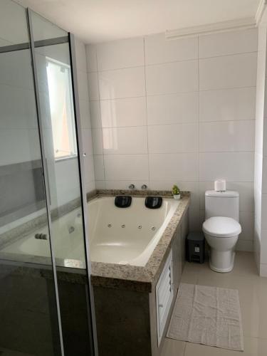 a bathroom with a shower and a tub and a toilet at Pousada VÔ REY in Penha