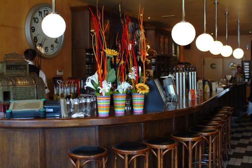 a bar with stools in a restaurant with a clock at Tuinhotel in Lommel