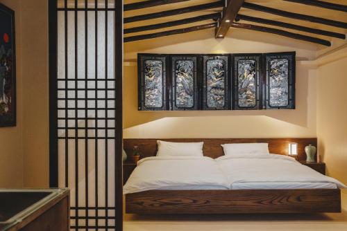 a bedroom with a bed and some stained glass windows at Korea's beauty in haeundae with Hinoki wooden bath in Busan