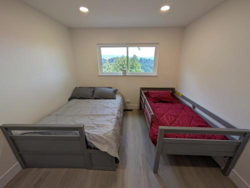 deux lits dans une petite pièce avec une fenêtre dans l'établissement Redwood Haven Your Santa Cruz Mountains Gateway, à Los Gatos