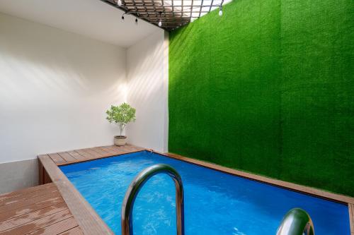 a pool in a room with a green wall at Villa INDOCHINA 7 bed room in Ho Chi Minh City