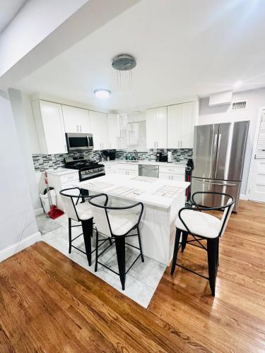 a kitchen with white cabinets and a table and chairs at Cheerful 4-bedroom home with free parking in Elmont