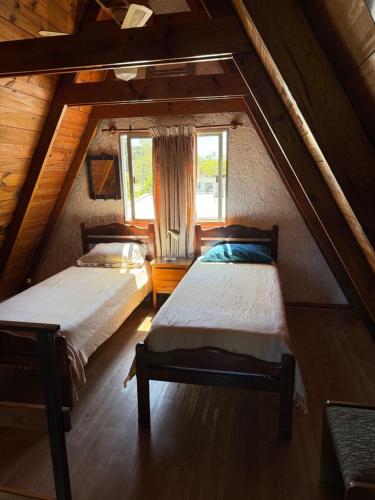 a attic bedroom with two beds and a window at Mar 11 a 100 mtros del mar in Parque del Plata