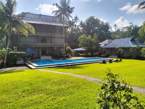 a house with a swimming pool and a yard at Villa Biyu siyu in Ubud