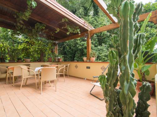 eine Terrasse mit Tisch und Stühlen und einem Kaktus in der Unterkunft Alla Corte del Re Dimora Storica in Neapel