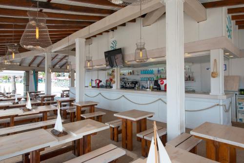 a restaurant with wooden tables and a bar at Iberostar Ciudad Blanca in Port d'Alcudia