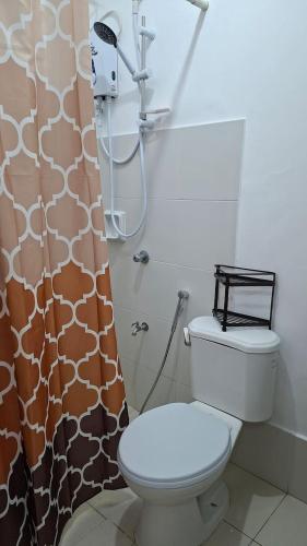 a bathroom with a toilet and a shower curtain at House Brown style in Lipa