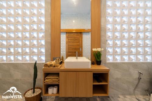 Bingin BeachにあるGovind Uluwatu Villa by Bukit Vistaの洗面台と鏡のあるバスルーム