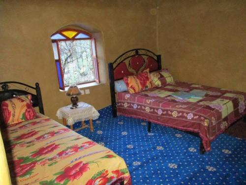 Un dormitorio con dos camas y una ventana en دار اوليم, en Annoums
