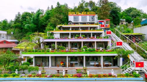 a building with a garden on the side of it at Sapa Village Hotel in Sapa