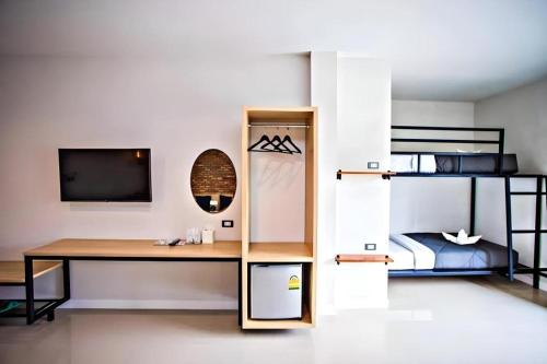 a bedroom with a desk and a bunk bed at Sabai @ Chiang Rai in Chiang Rai