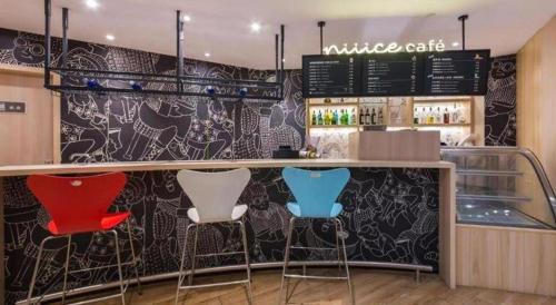 a bar with four stools in a restaurant at Ibis Xinzhou Qiyi RD in Xinzhou