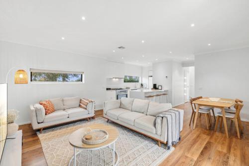 Una sala de estar con dos sofás y una mesa. en 3BR Retreat Mount Duneed, en Grovedale