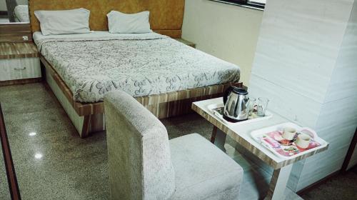 een kamer met een bed, een stoel en een tafel bij Hotel chhaya in Aurangabad