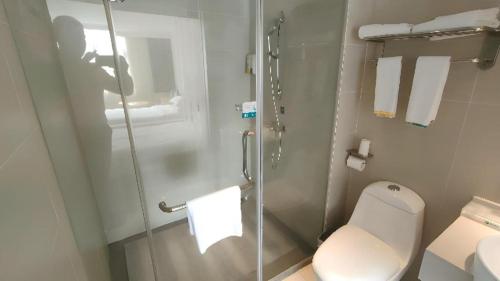 a bathroom with a toilet and a glass shower at City Comfort Inn Shenzhen International Exhibition Center Tangwei Metro Station in Shenzhen