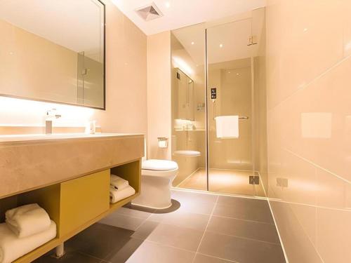 a bathroom with a sink and a toilet and a shower at City Comfort Inn Nanning Yudong Jinxiang Metro Station in Nanning