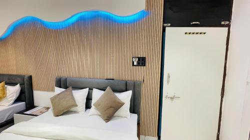 a bedroom with a bed with white sheets and pillows at GM Residency in Varanasi