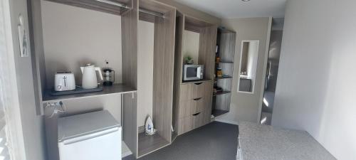 a small kitchen with a sink and a microwave at Hidden Gem in Oaklands in Napier