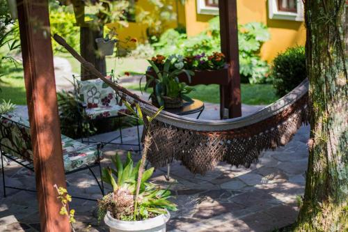 a hammock with potted plants in a garden at Hotel Pousada do Bosque in Canela