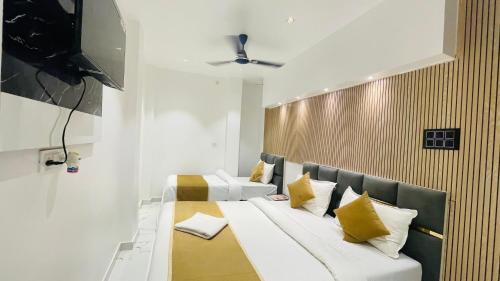a bedroom with two beds with yellow pillows at GM Residency in Varanasi
