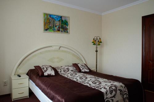 a bedroom with a bed and a painting on the wall at Argo Premium in Lviv