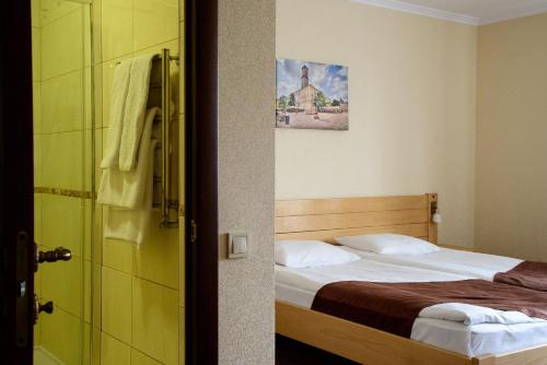 a bedroom with a bed and a glass shower at Argo Premium in Lviv