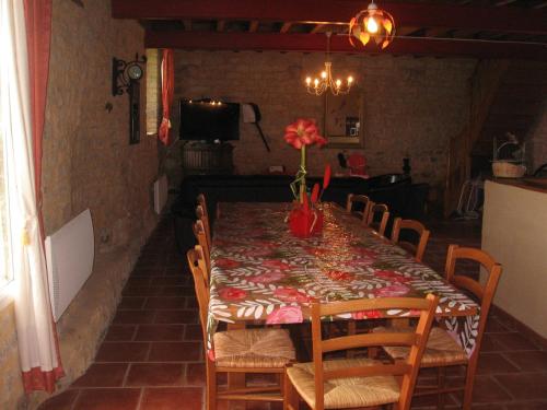 a dining room table with a table cloth with flowers on it at La Ferme de Montigny (Gite) in Asnières-en-Bessin