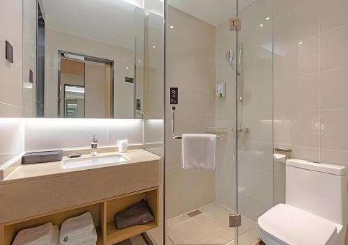 a bathroom with a sink and a glass shower at City Comfort Inn Hotel Jinhua Dongyang First Department Store in Dongyang