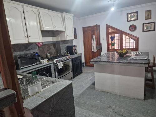 a kitchen with white cabinets and a counter top at Casa blanca alojamientos in Manta
