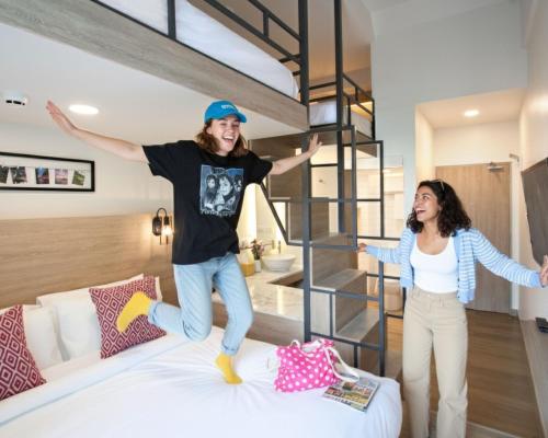 a man and a woman jumping on a bed at Lub d Manila Makati - Central Makati, Near Nightlife in Manila