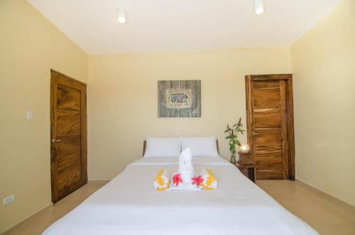 a bedroom with a white bed with two wooden doors at Boracay Amor Apartment in Boracay