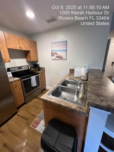 a kitchen with a sink and a counter top at Blue Horizon With Shared Spaces in Riviera Beach