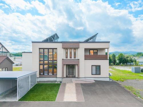 a large white house with a lot of windows at The BEEHIVE KAMIFURANO in Kami-furano
