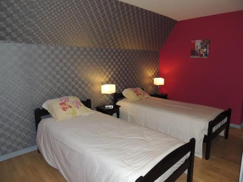 2 letti in una camera d'albergo con pareti rosse di Beluga a La Godivelle