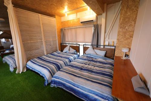 two beds sitting next to each other in a bedroom at HB01 テントと芝生が広がるお部屋 小田原港3分 8名可 箱根板橋駅徒歩8分 早川駅徒歩7分 Tent and lawn room Odawara Port 3 minutes 8 people Hakone Itabashi Station 8 minutes on foot Hayakawa Station 7 minutes on foot in Odawara