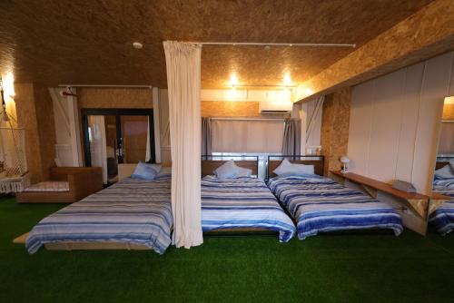 two large beds in a room with green grass at HB01 テントと芝生が広がるお部屋 小田原港3分 8名可 箱根板橋駅徒歩8分 早川駅徒歩7分 Tent and lawn room Odawara Port 3 minutes 8 people Hakone Itabashi Station 8 minutes on foot Hayakawa Station 7 minutes on foot in Odawara