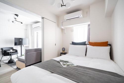 a bedroom with a large bed and a chair at Daffitto Oshiage I in Tokyo