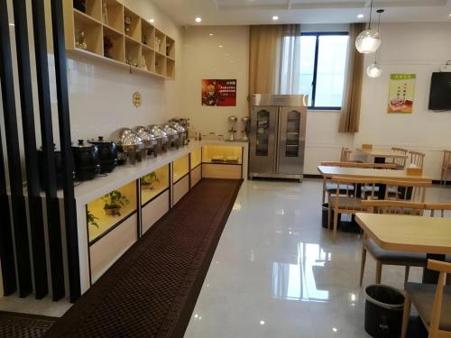 a restaurant with a kitchen and a dining room at GreenTree Alliance Hotel Suzhou Dangshan Lihua Square in Dangshan