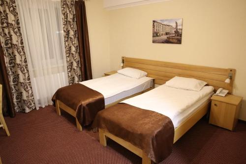 a hotel room with two beds and a window at Argo Premium in Lviv