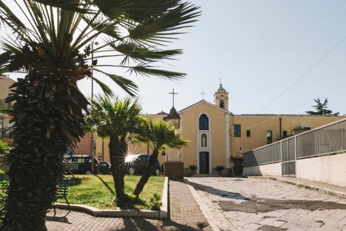 a church with palm trees in front of a street at Casa Vacanze Patrizia in Montescaglioso