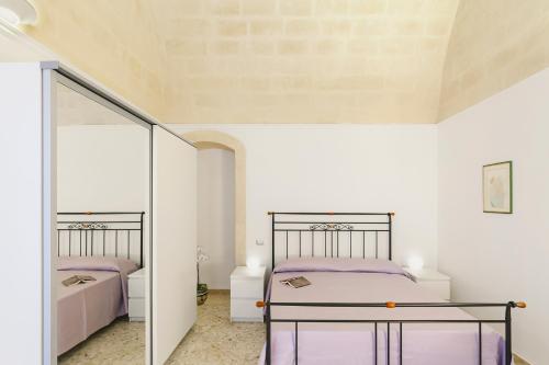 a bedroom with two beds and a mirror at Casa Vacanze Patrizia in Montescaglioso