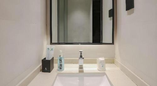 a bathroom sink with two toothbrushes and a mirror at City Comfort Inn Jiyuan Jishui Avenue Jigang in Jiyuan