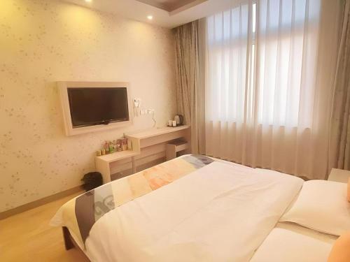 HuainanにあるShell Hotel Anhui Huainan Tianjia'an District Longhu Nan Roadのベッドと薄型テレビのある寝室