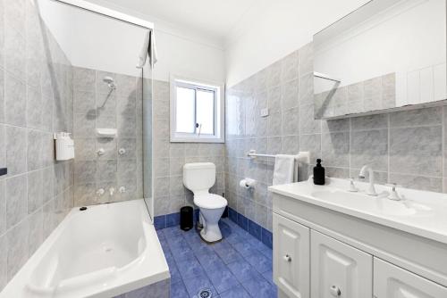 a white bathroom with a sink and a toilet at Barronstown - Pet Friendly with Fire Pit in Callala Beach