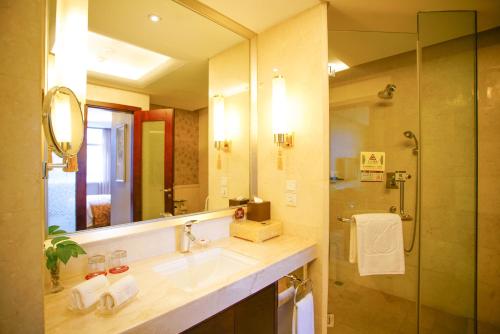 a bathroom with a sink and a shower and a mirror at Grand Soluxe Hotel Xi'an in Xi'an